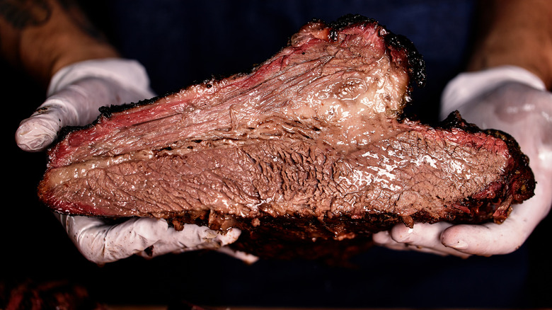 Person holding smoked texas style brisket