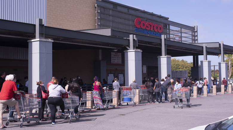 People patiently lining up outside of a busy Costco