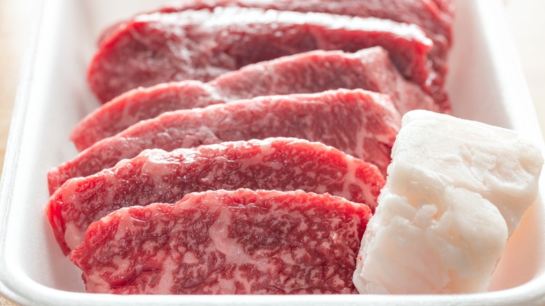 Raw slices of beef steak and tallow