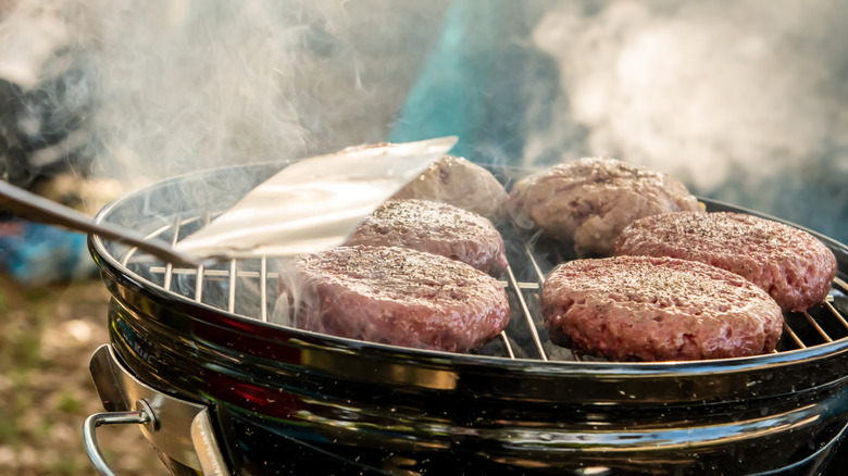 Turkey burger patties cooking on charcoal grill