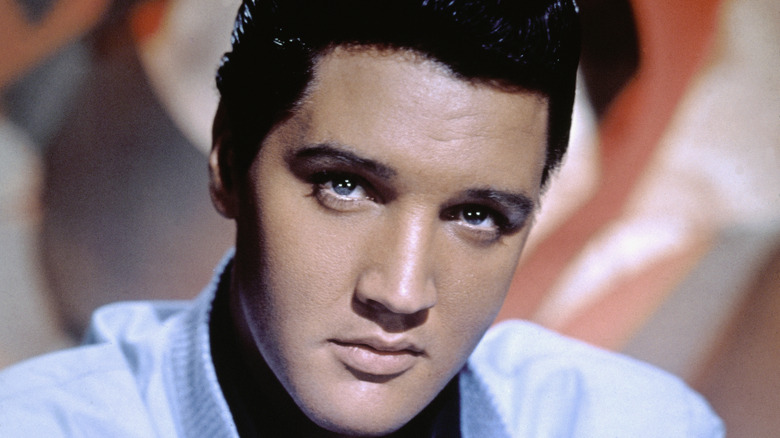 Closeup color photo of Elvis Presley with a somber expression