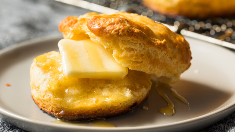 Sliced biscuit with a pat of melting butter on a plate