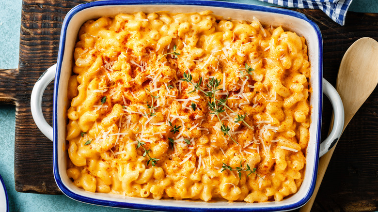 A casserole dish full of mac and cheese with some Buffalo seasoning on top.