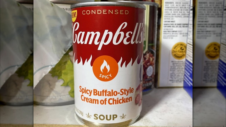 A can of Campbell's soup sits on a pantry shelf.