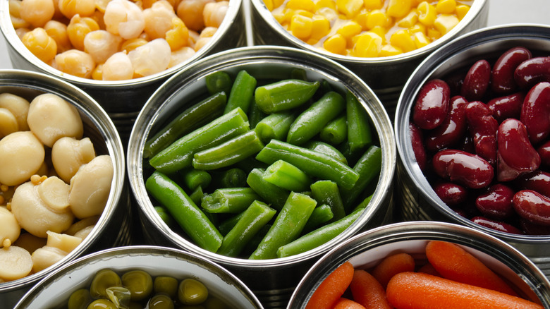 Canned vegetables sit with their lids off.