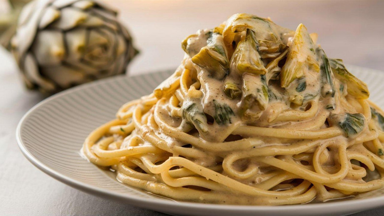 Creamy artichoke pasta served on a plate.