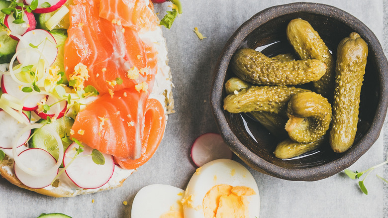 Bagel sandwich with a side of pickles
