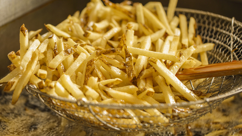 Frying french fries in hot oil with fry basket