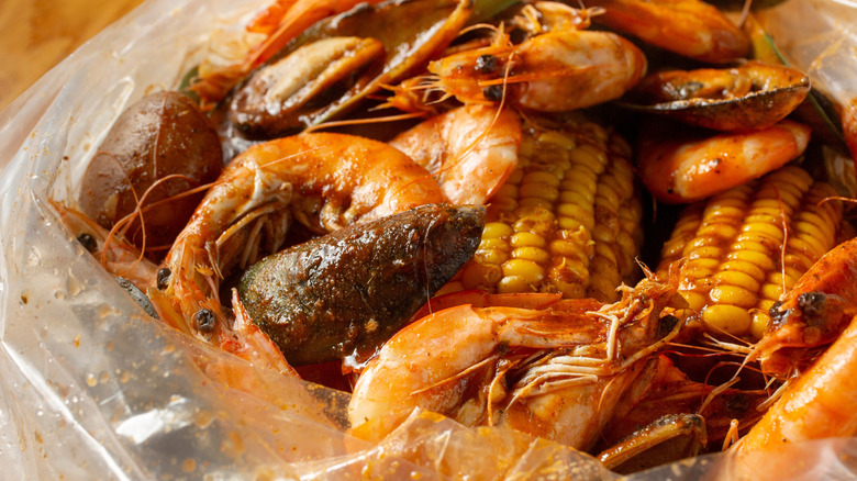 The ingredients of a seafood boil sit in a plastic bag