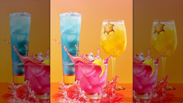 A trio of colorful Red Lobster beverages sit against an orange background
