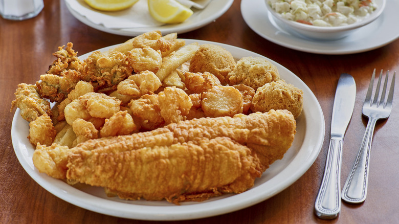 A fried seafood platter sits on a restaurant table.