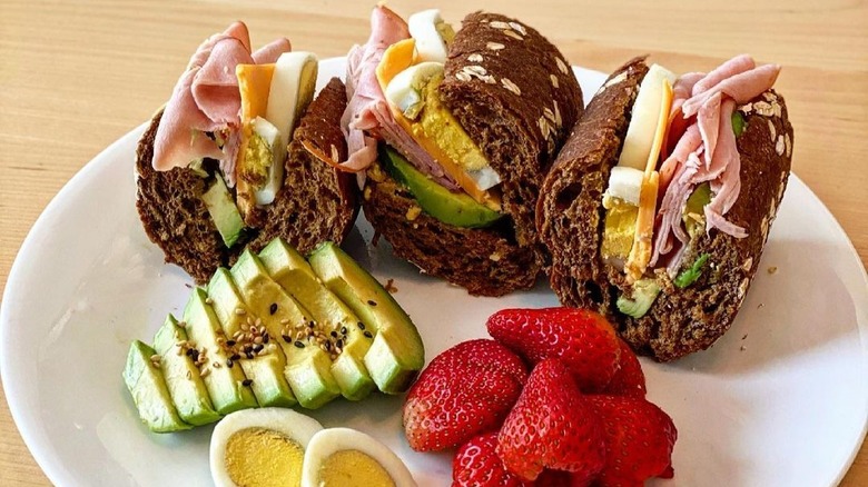 Homemade sandwich with lunchmeat eggs and avocado on brown bread from Cheesecake Factory