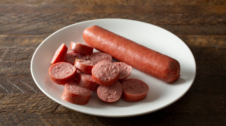 A whole hot dog and hot dog slices on a plate