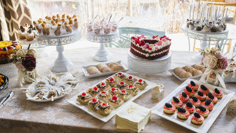 A table sits full of vintage desserts from a Jell-O mold to ambrosia to petit fours