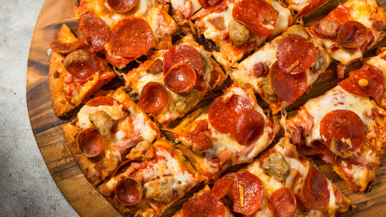 Close-up of tavern-style pizza topped with pepperoni and sausage.