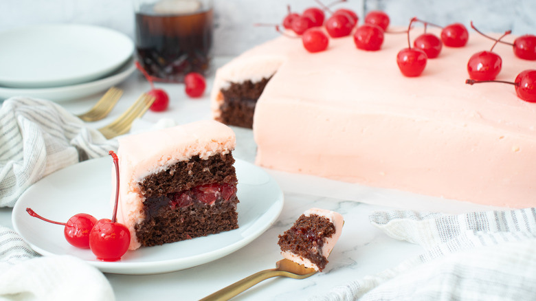 pink-frosted cake with cherries on top