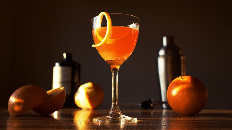 Orange cocktail with twist in Nick & Nora glass