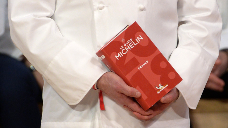 Chef holding Michelin Guide 2018