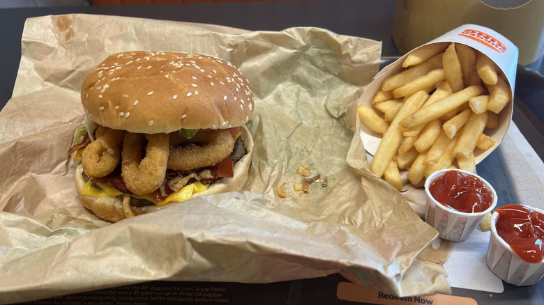 Burger King Whopper stuffed with onion rings and a side of fries.