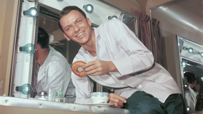 Frank Sinatra having a donut and coffee in a dressing room