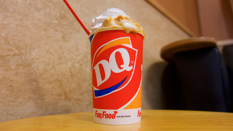 A Dairy Queen Blizzard sits on a table with a red spoon in it