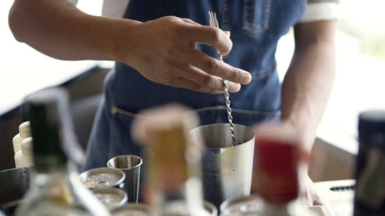 bartender stirring cocktail with cocktail spoon