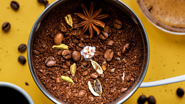 various whole spices inside a grinder