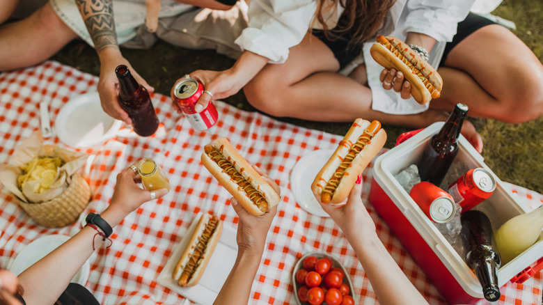 People eating hot dogs at a picnic