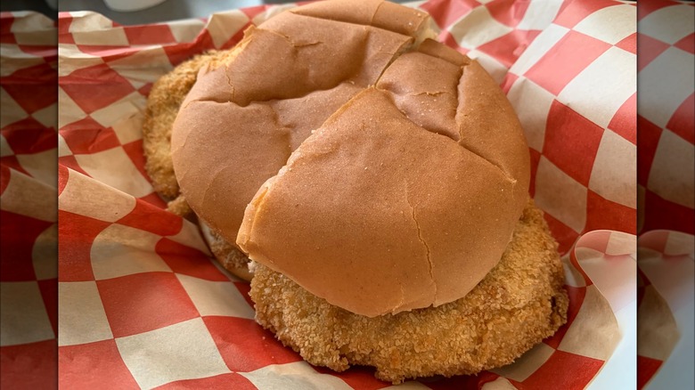 Indiana-style fried pork tenderloin sandwich on checkered paper
