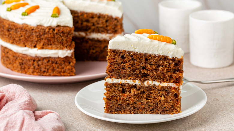 Slice of carrot cake on plate taken out of full cake