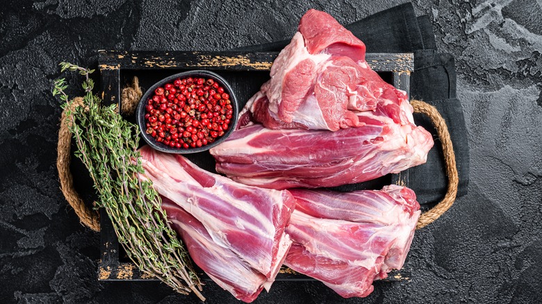 lamb shank beside bowl of berries and rosemary sprigs