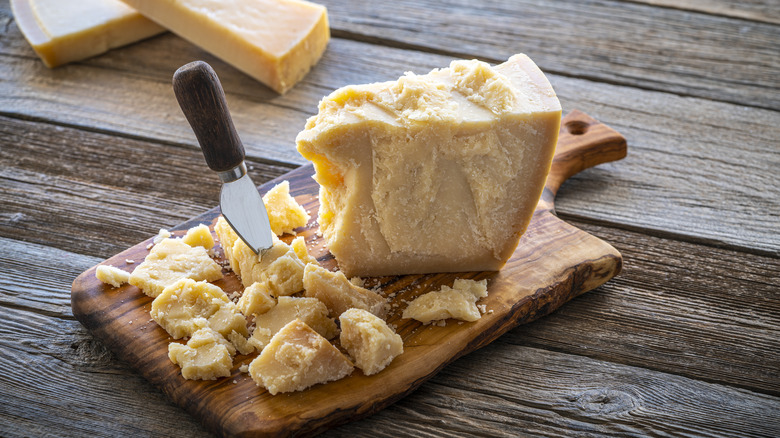 Chunks of Parmesan cut off wedge on board