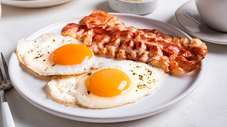 a plate of bacon and fried eggs