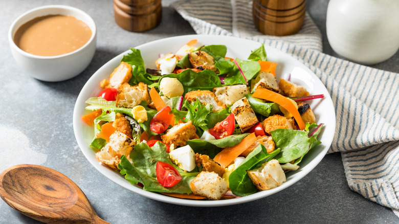 An Italian salad with dressing on the side.