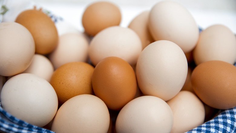 A variety of eggs in a basket.