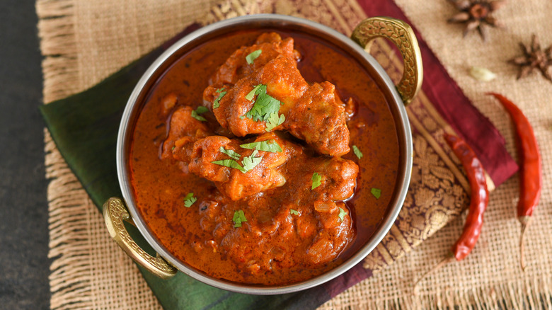 Metal serving bowl of butter chicken