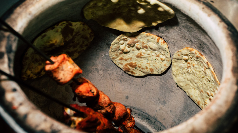 Making naan and tandoori chicken in tandoor