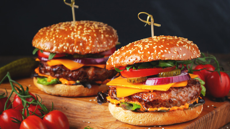 two cheeseburgers on wooden board