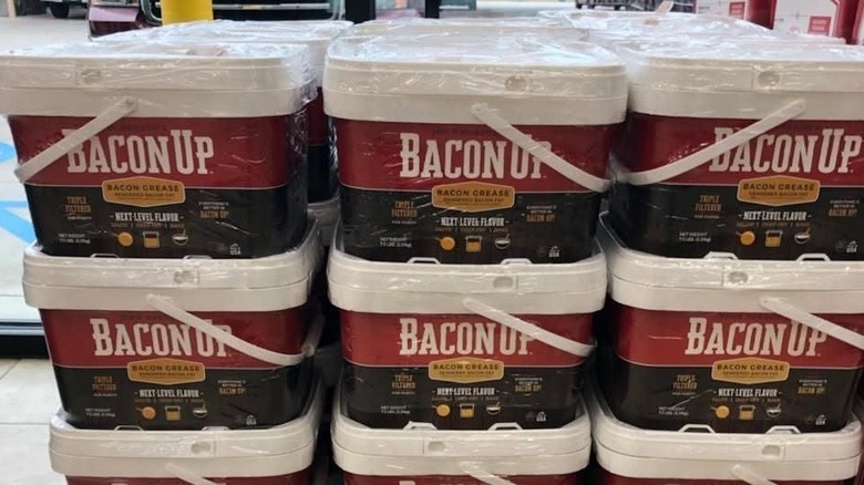 Buckets of bacon grease sit on a store floor