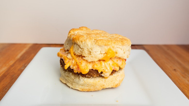 Steak egg and cheese biscuit sandwich on white plate