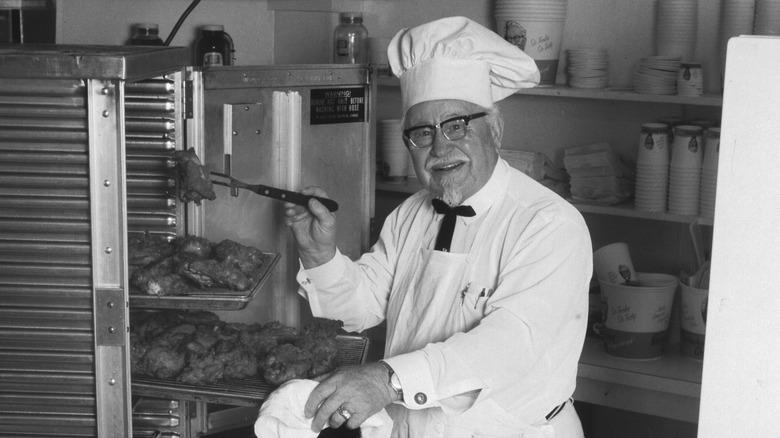 Colonel Sanders, the founder of KFC, handling a tray of fried chicken