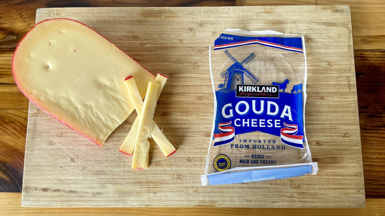 Kirkland Signature Gouda Cheese on a cutting board next to its empty package.