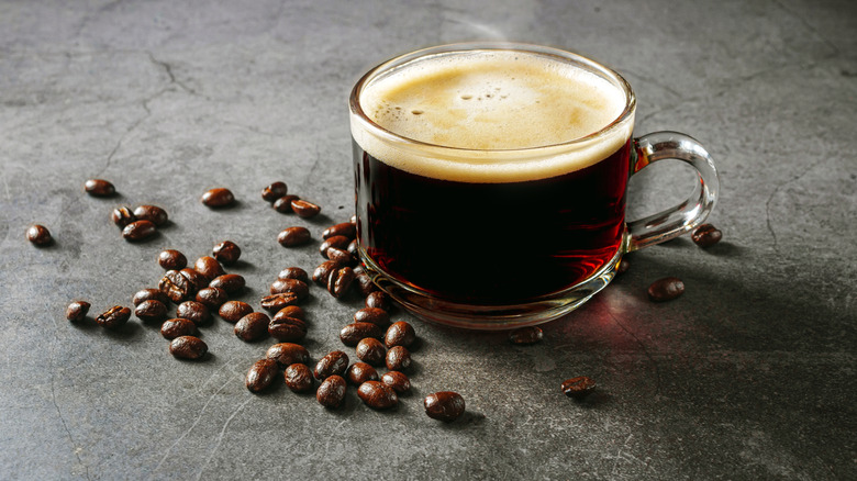 Steaming cup of coffee and beans