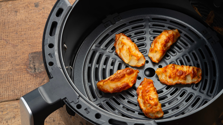 Crispy potstickers at the bottom of an air fryer basket