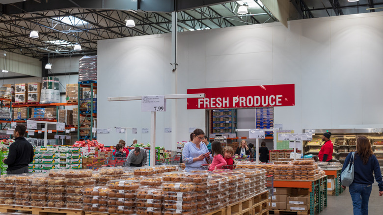 Shoppers going through the bakery section of a Costco, right outside the Produce section