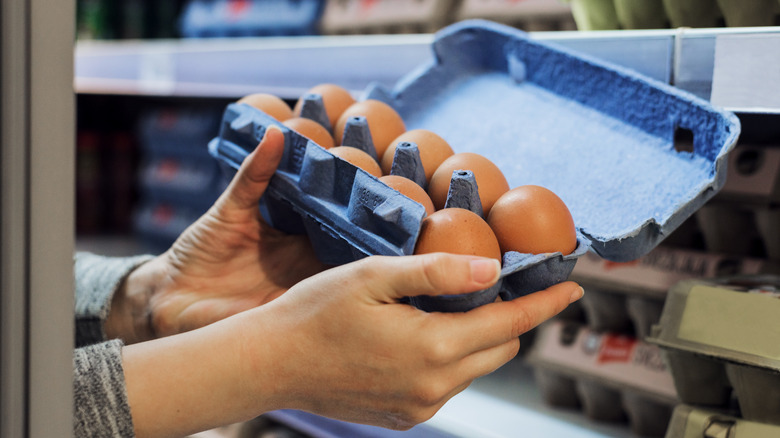 Person holding container of eggs