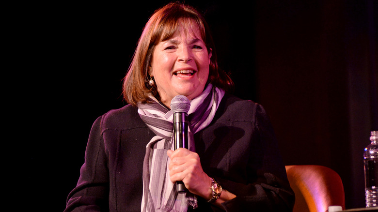 Ina Garten holding a microphone and smiling.