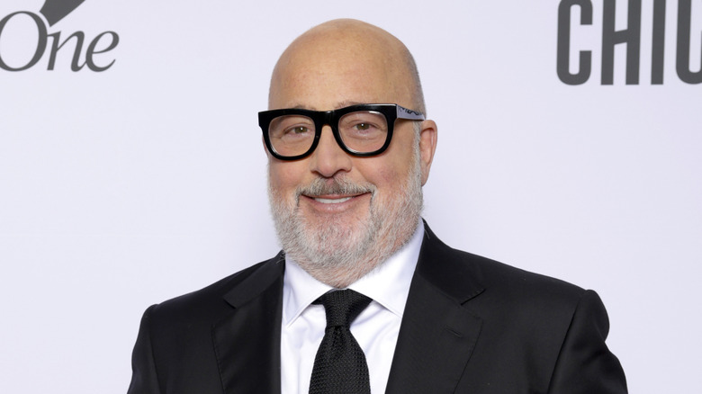 Andrew Zimmern wearing a black suit and tie