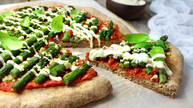 Vegan pizza with whole wheat crust, asparagus, cashew cheese sauce