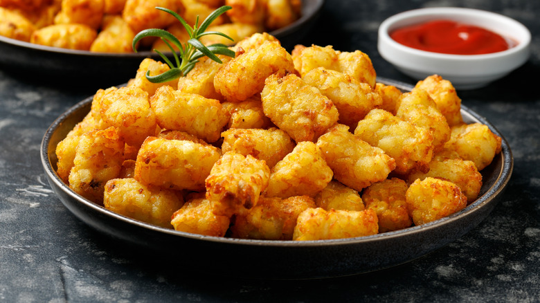 Tater tots in a wide black bowl